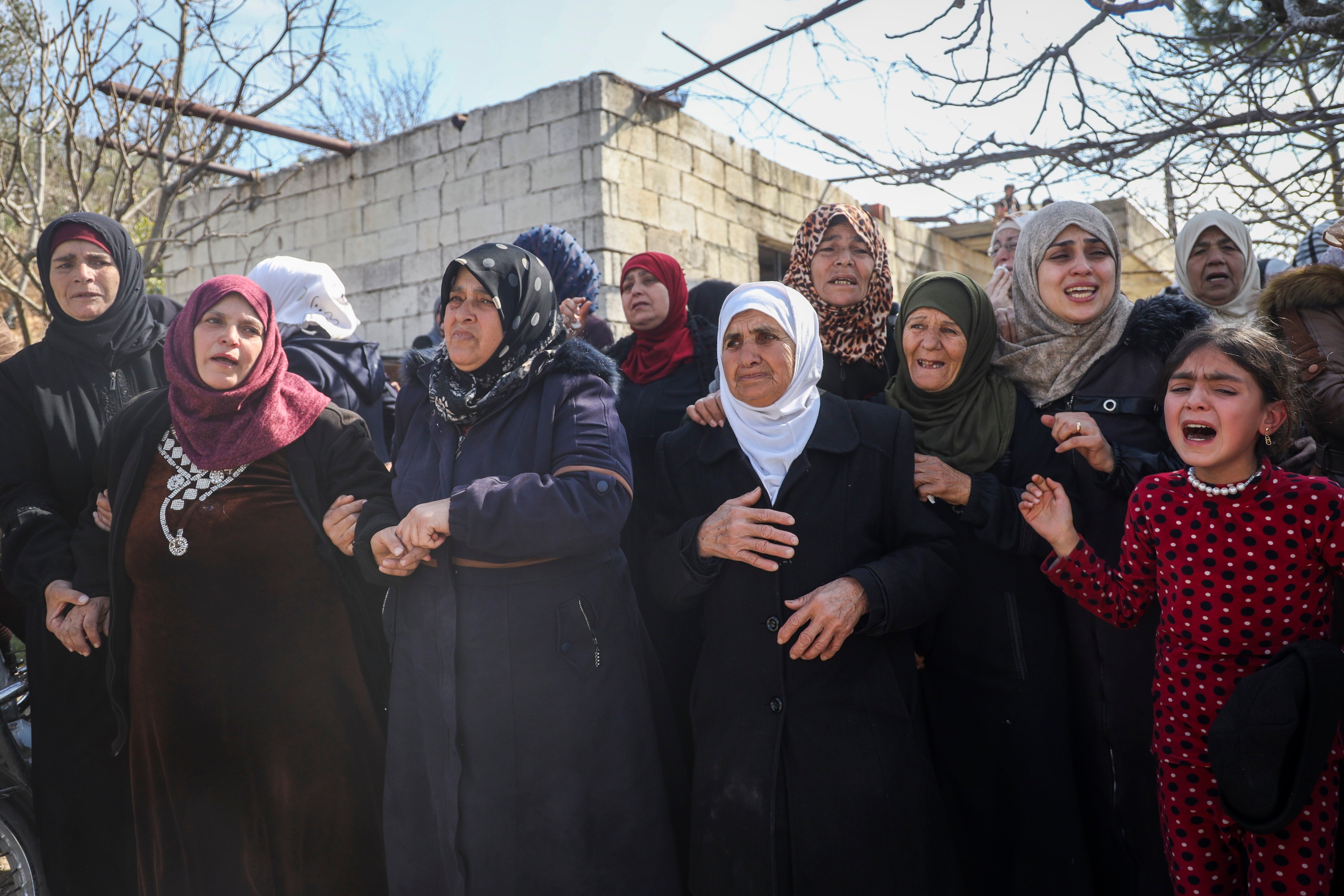 Relatives and neighbours mourn during the funeral procession for four Syrian security force members killed in clashes with loyalists of ousted President Bashar Assad in coastal Syria, in the village of Al-Janoudiya, west of Idlib, Saturday, March 8, 2025. (AP Photo/Omar Albam)