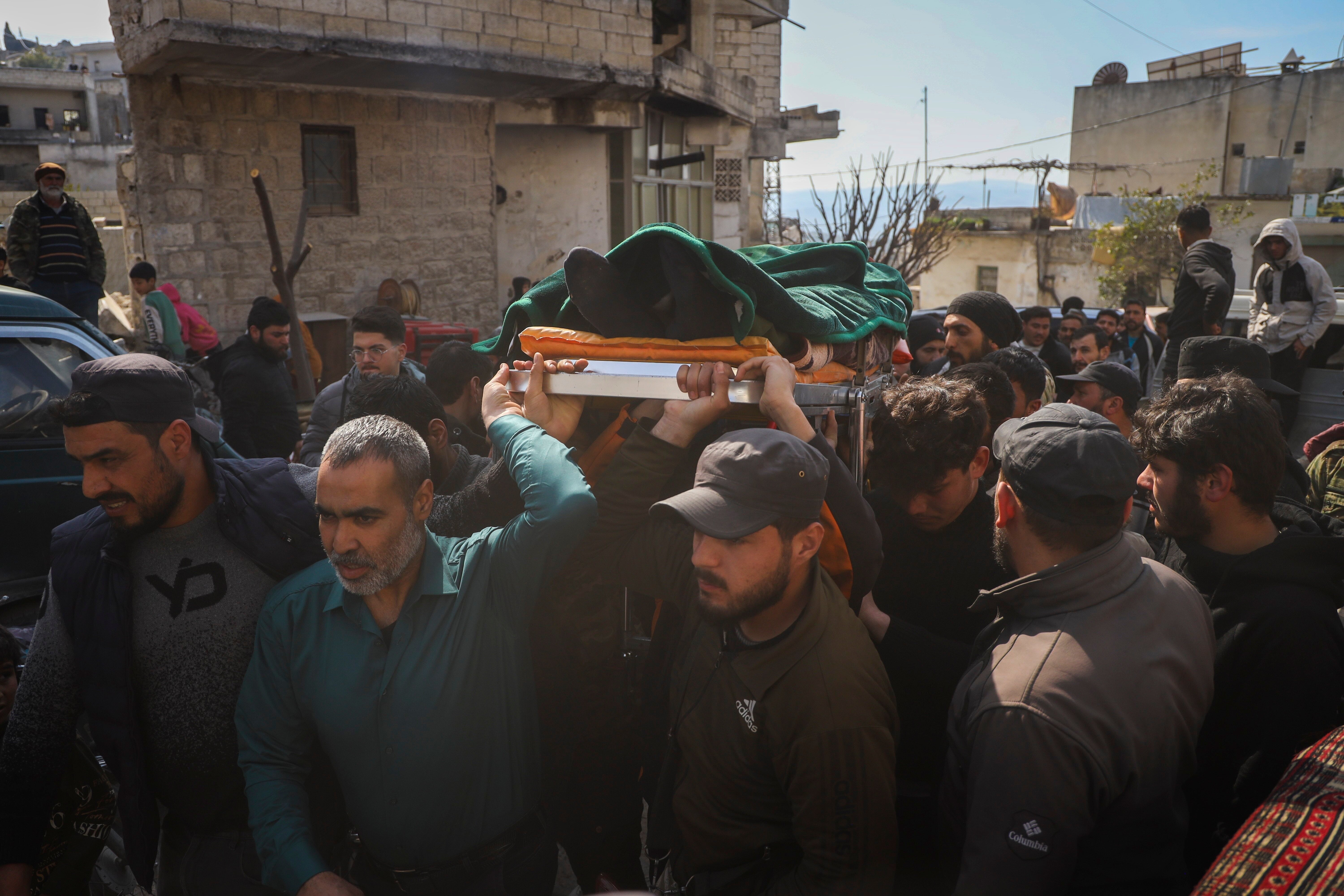 The body of a Syrian security force member killed in clashes with loyalists of ousted President Bashar Assad in coastal Syria, is carried for burial in the village of Al-Janoudiya, west of Idlib, Saturday, March 8, 2025. (AP Photo/Omar Albam)