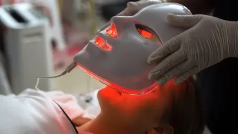 Getty Images Portrait of a woman getting red LED treatment