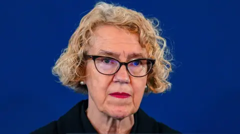 PA Media Lady Justice Thirlwall, who has curly blonde hair and is photographed wearing dark glasses. She is in front of a dark blue backdrop.