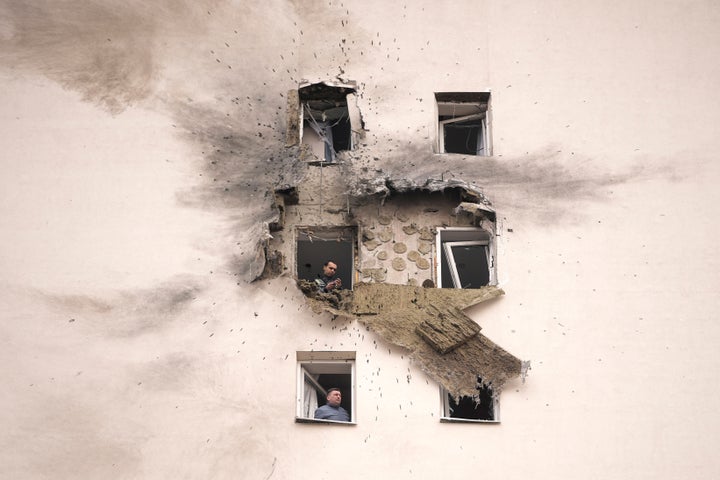 Investigators look at the damage of an apartment building where the downed Ukrainian drone fell in Sapronovo village outside Moscow, Russia, on March 11, 2025.